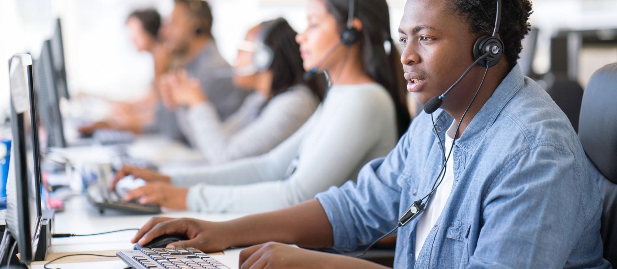 Photo of claims agents with headsets waiting to help you file your car insurance claim.