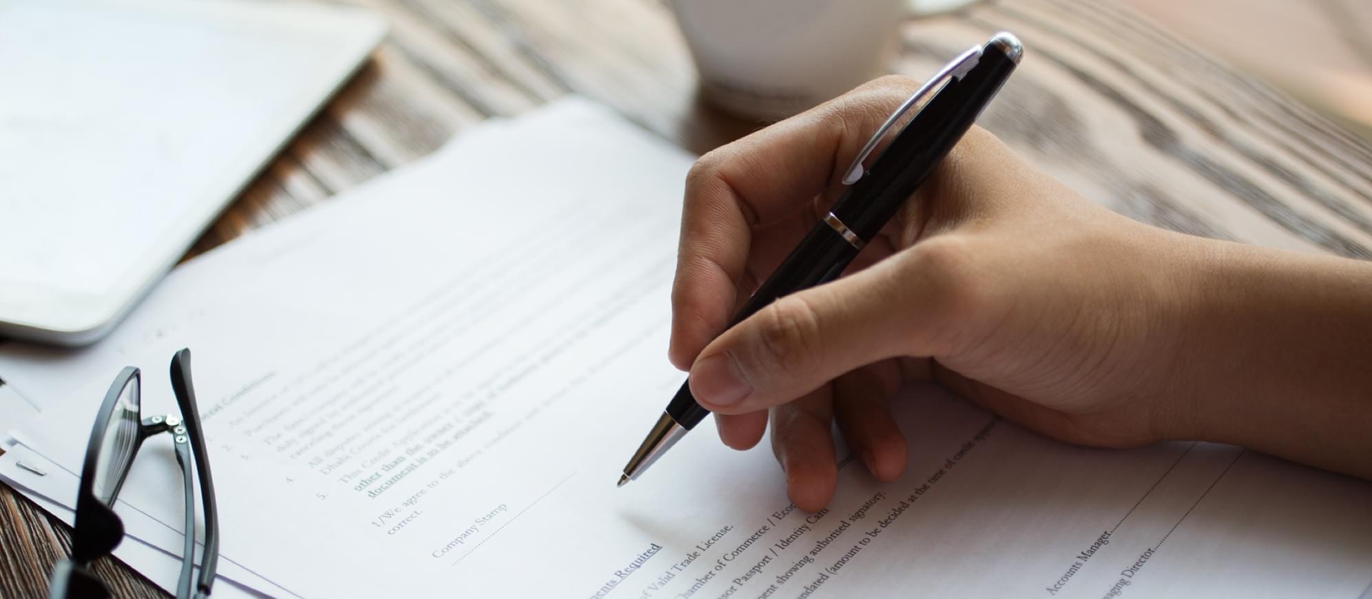 Image of a person signing a contract after buying car insurance with SR-22 certificate from The General.